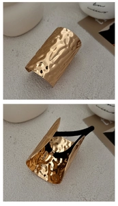 Detail of golden hammered metal hair ring showing front texture and back elastic structure