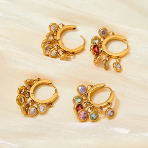 Detailed view of gold hoop earrings with vibrant colorful cubic zirconia charms on silk