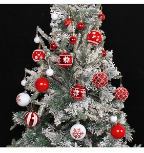 Detailed close-up of red and white patterned Christmas ornaments hanging on a snowy tree