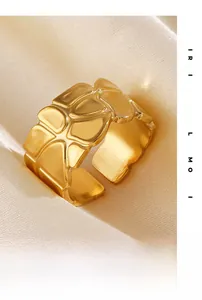 Makroaufnahme eines goldfarbenen breiten Rings mit unregelmäßigem Giraffenmuster auf Satin