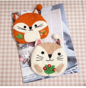 Detail of cute handmade wool felt fox and squirrel coin purses with fuzzy textures
