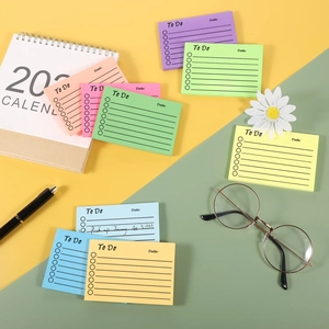 Flat lay of colorful 'To Do' list sticky notes with pen and glasses for productivity