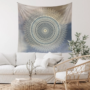 Detailed view of bohemian mandala tapestry hanging above a modern sofa in a bright room