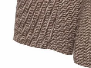 Macro shot of brown herringbone wool fabric texture on a fashion blazer suit