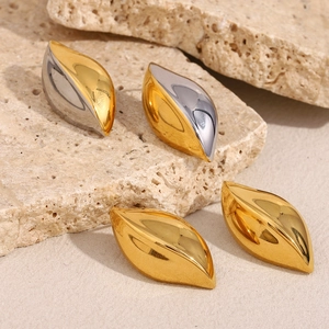 Polished 18K gold stainless steel eye-shaped earrings on a textured stone surface
