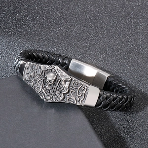 Men's black braided leather bracelet with silver skull and scrollwork stainless steel clasp
