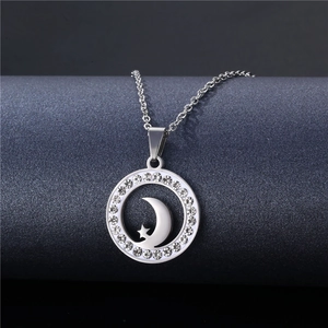 Detail of a stainless steel circle pendant with sparkling crystals and star-moon cutout