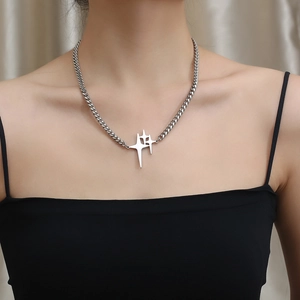 Star cross pendant cuban link necklace in titanium steel worn by model on beige background