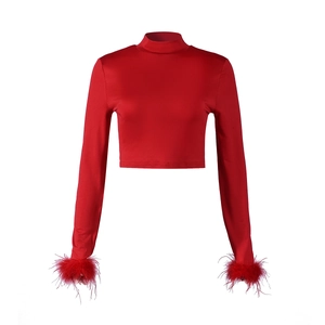 Detail of red mock neck crop top featuring elegant feather trim on long sleeves