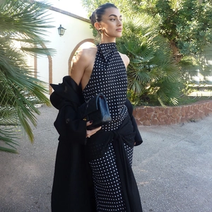 Detail of elegant black and white polka dot sleeveless halter maxi dress with open back
