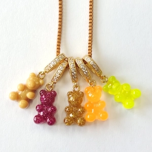 Detail von fünf bunten Harzbären-Anhängern mit funkelnden Kristallen an goldener Kette