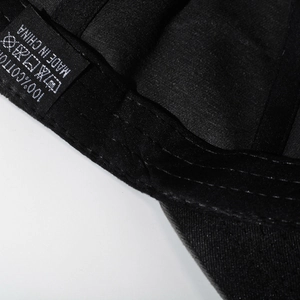 Détail interne d'une casquette en coton délavé avec étiquette 100% coton et coutures