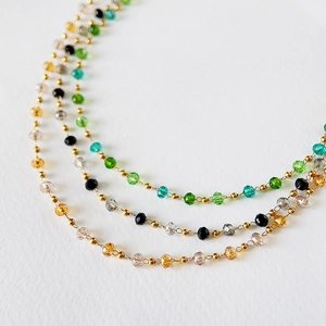 Detail of colorful faceted crystal beads with gold spacing beads on handmade choker chains