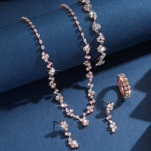 Dettaglio macro del set di gioielli in oro rosa con cristalli scintillanti su collana e orecchini