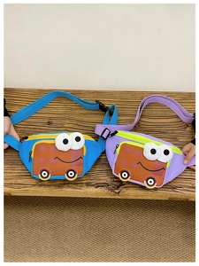 Detail view of colorful cartoon bus nylon waist bags for kids on wooden background