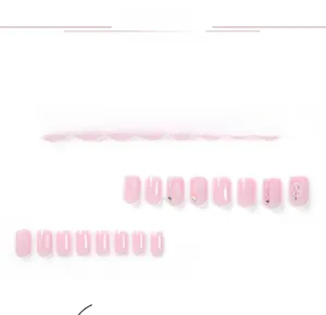 Detailed set of 24 pink press-on nails with white grid patterns and delicate rhinestones