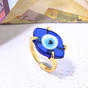 Macro shot of gold adjustable ring featuring blue glass evil eye with intricate details