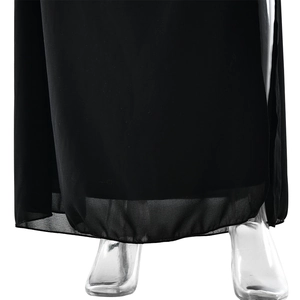 Détail de l'ourlet de la robe en mousseline noire avec un drapé fluide et tissu de qualité