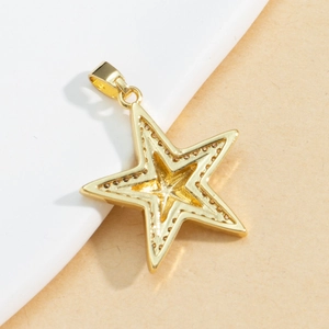 Gold star pendant with dotted texture and zircon inlay on a minimalist studio background