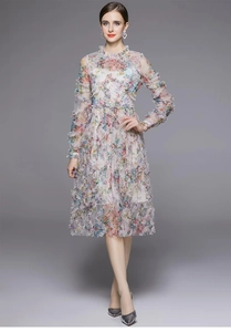 Detalle de vestido de gasa con estampado floral multicapa con encaje plisado y manga larga
