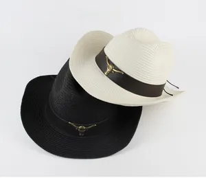 Detail of western straw cowboy hats featuring leather bands and metal bull head ornaments