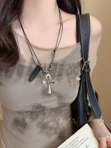 Dettaglio della collana a doppio cordino nero con ciondolo a croce Ankh d'argento