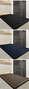 Three rectangular entryway mats in black, navy, and brown with geometric texture