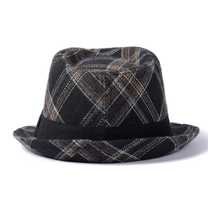 Detailed macro shot of vintage plaid patterns and black ribbon on a felt fedora hat