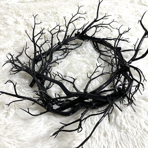 Halloween black dry twig wreath for wall decoration on white plush background