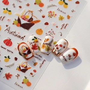5D autumn themed nail stickers featuring pumpkin and maple leaf designs on warm orange nails
