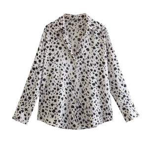 Détail d'une chemise en satin à imprimé léopard avec col rabattu et boutons