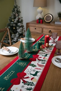 Close-up of woven Christmas table runner with reindeer motifs and festive holiday decor
