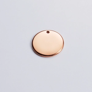 Macro view of polished rose gold round pendant with hole for jewelry engraving