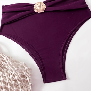 Detail of high-waisted purple bikini bottom with pleated waist and golden shell ornament