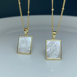 Detail of square gold necklaces with mother of pearl Virgin Mary religious pendants