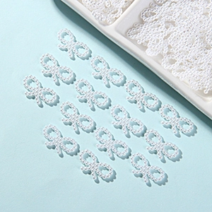 Flat lay of multiple white ABS pearl bow charms for DIY phone case and mug decoration