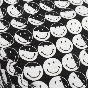 Détail macro du tissu sergé avec motif imprimé smiley et yin-yang noir et blanc