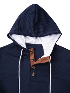 Detail of navy textured hoodie featuring a brown contrast placket and white drawstrings