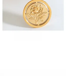 Macro shot of a vintage golden rose pendant with detailed floral relief engraving
