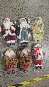 Detailed view of six assorted standing Santa Claus dolls in festive fabric costumes
