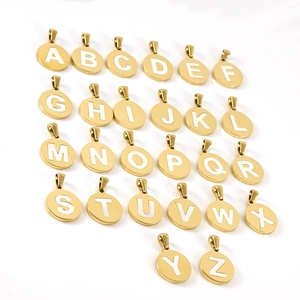 Collection of 26 gold round initial pendants with white shell inlay on white background