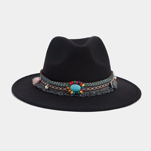 Détail du chapeau en feutre noir avec bande ethnique, glands et pierre turquoise