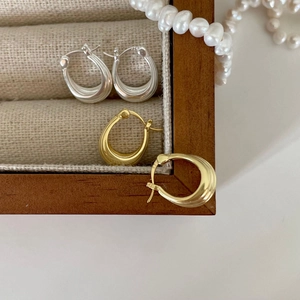 Minimalist 925 sterling silver hoop earrings in gold and silver finish on linen