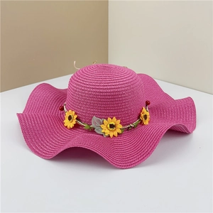 Detail view of woven straw hat with wavy brim and colorful sunflower decoration