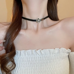 Détail du collier choker fleur de camélia sombre plaqué or et zircons sur cuir noir
