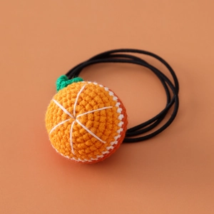 Close-up of handmade crochet orange hair tie with elastic band for girls