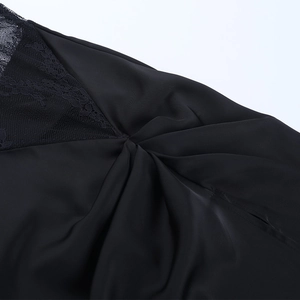 Détail de dentelle noire délicate et de tissu en soie plissée sur une robe de soirée