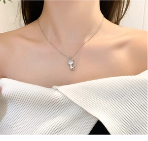 Silver cat pendant necklace with round zircon stone worn on a model's neck