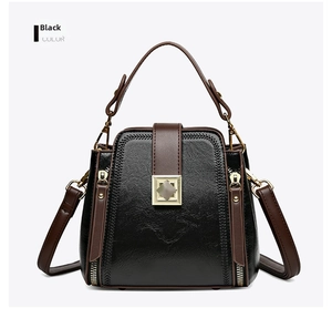 Detail showing high-quality black lychee texture leather with brown trim and gold hardware