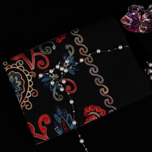 Detail of floral embroidery on thick black pashmina scarf with luxury pearl accents